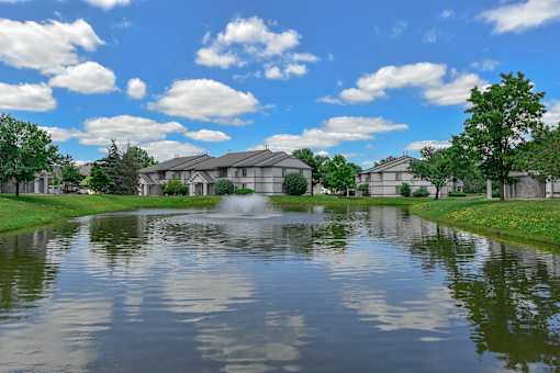 A pond in front of a row of houses.