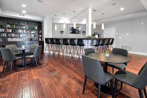 A room with a long table and chairs and a bookshelf.