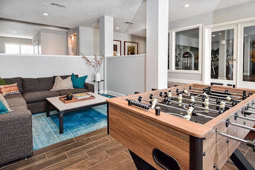 A foosball table sits in the middle of a living room.