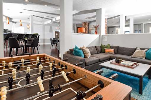 A foosball table is in the middle of a living room.