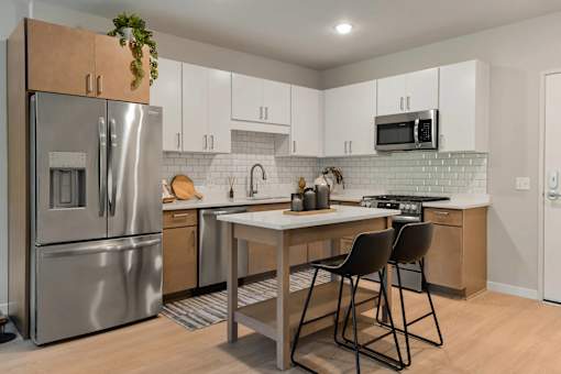 A kitchen with a table and chairs.