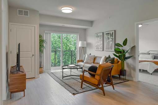 A living room with a white couch, a wooden chair, and a television.