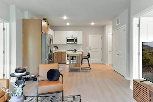 A modern living room with a black chair and a wooden floor.