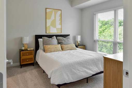 A bedroom with a large bed and a painting above it.