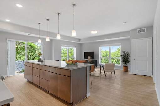 A modern kitchen with a wooden island and pendant lights.