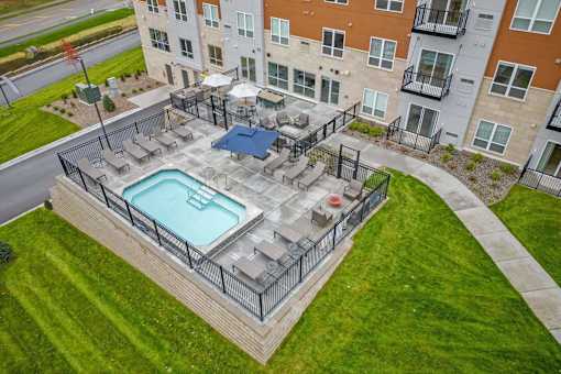 A swimming pool surrounded by a fence in a grassy area.