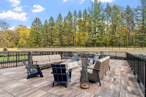A wooden deck with chairs and skis on it.