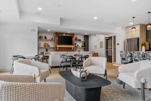 A living room with a black coffee table and white chairs.