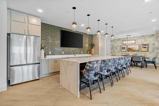 A modern kitchen with a long island and chairs.