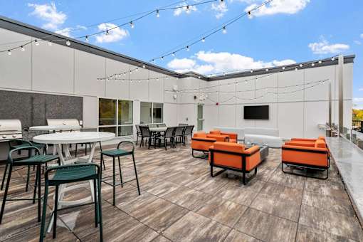 A patio with a table and chairs is set up on a wooden deck.