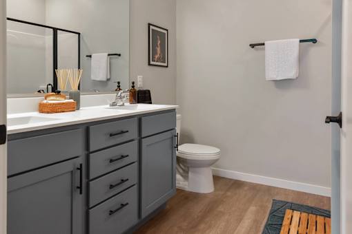 A bathroom with a white toilet and a sink with a basket on it.