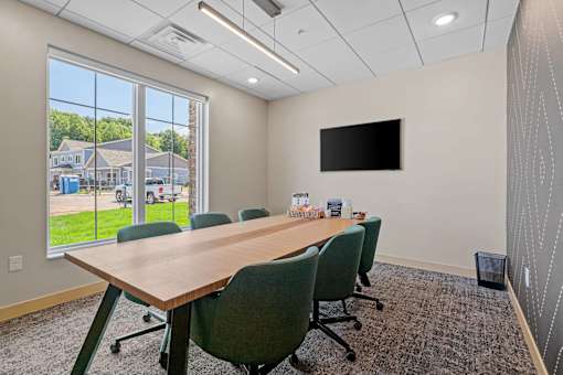 A conference room with a long table and chairs.