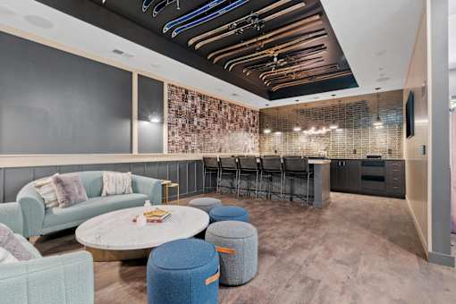 A modern living room with a large couch, a coffee table, and a bar area.