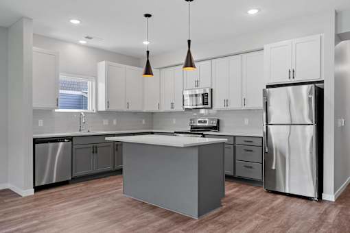 A modern kitchen with a central island and stainless steel appliances.