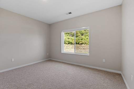A room with a window showing greenery outside.
