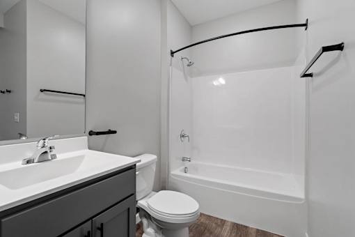 A white bathroom with a toilet, sink, and bathtub.