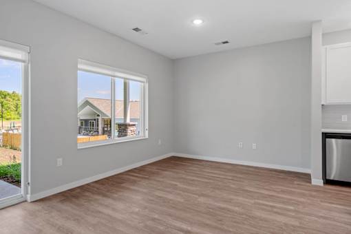 A room with a large window and a wooden floor.