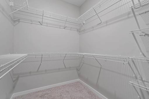 Empty shelves in a white pantry.
