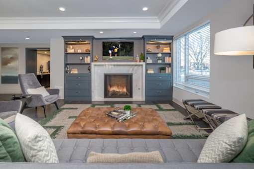A modern living room with a fireplace and grey couches.