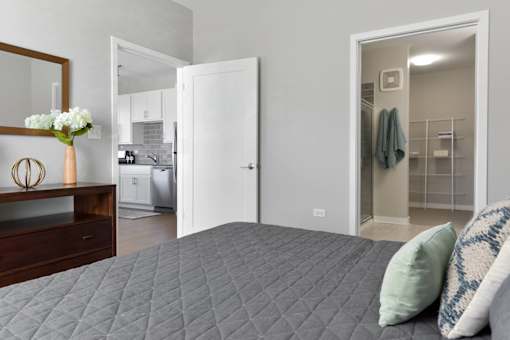 A bedroom with a bed, a dresser, and a mirror.