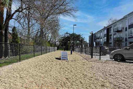 A residential area with a fenced yard and a car parked on the side.
