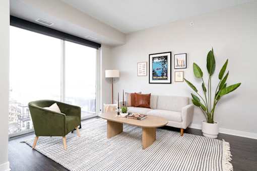 A living room with a green chair, a white couch, and a coffee table.