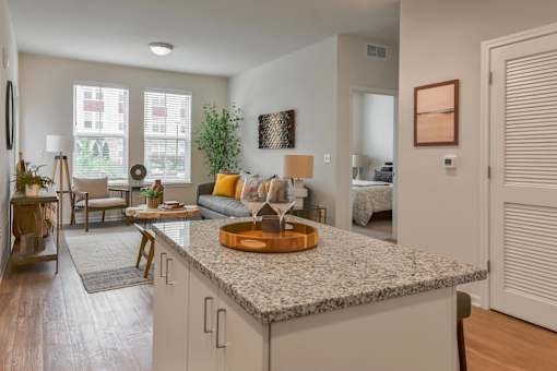 A kitchen with a granite countertop and a dining area with a table and chairs.