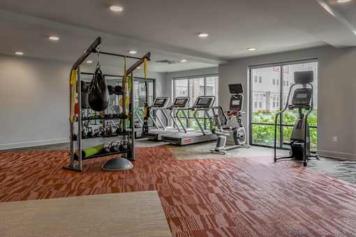 A gym with a red floor and various exercise equipment.