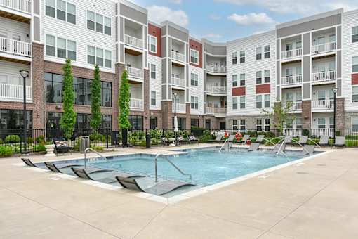 A swimming pool in front of apartment buildings.