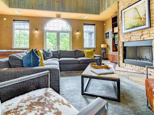 A living room with a grey couch and a fireplace.