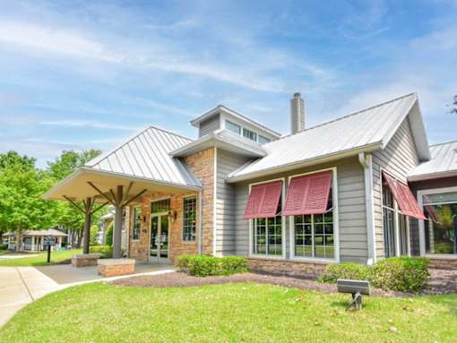 A modern house with a grey exterior and a red awning.