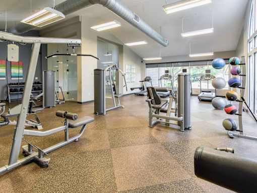 A gym with a variety of equipment including weights and machines.