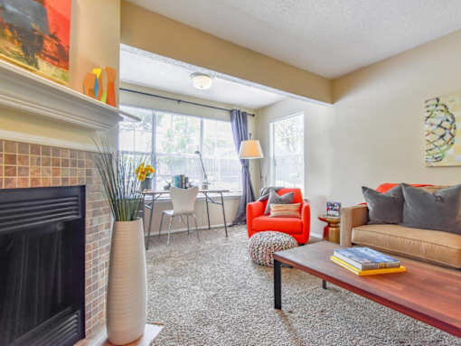 A living room with a fireplace, chairs, and a couch.