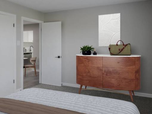 A bedroom with a bed, dresser, and chair.