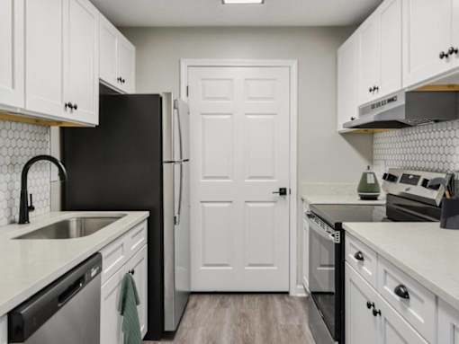 Kitchen with white cabinets and stainless steel appliances at Riverset Apartments modern apartments in Memphis, TN.