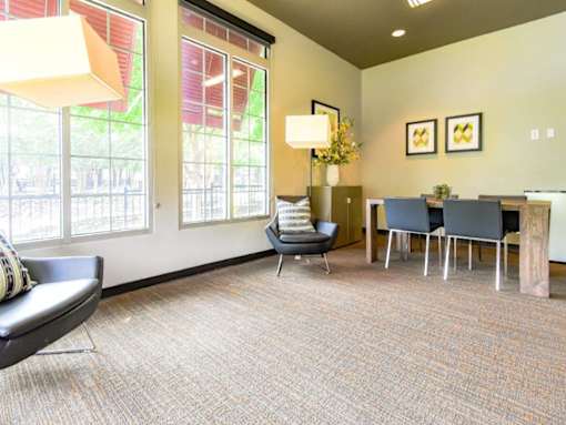 A waiting room with a chair, a table, and a lamp.
