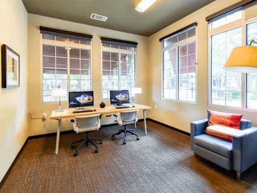 A room with two computers and a couch.