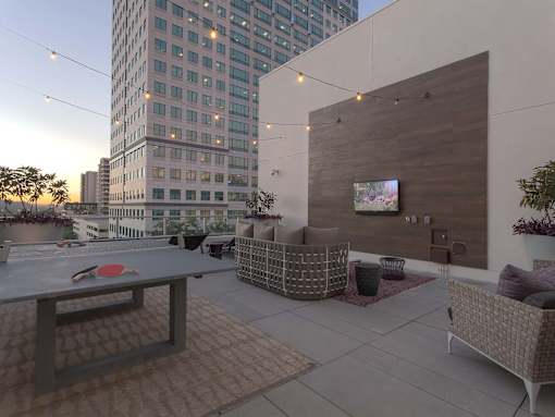 A patio with a table, chairs and a television on the wall.