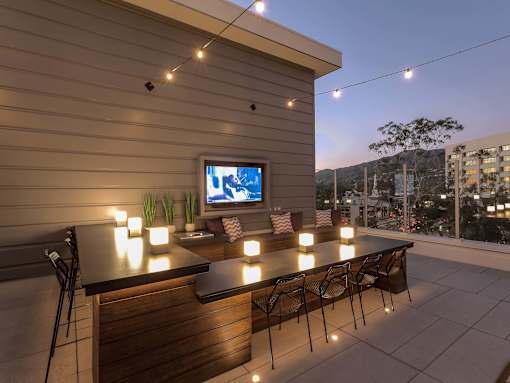 A patio with a bar and chairs is set up for an evening of relaxation.