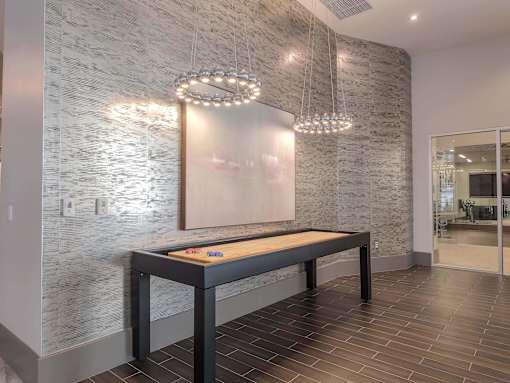 A modern dining room with a wooden table and a chandelier.