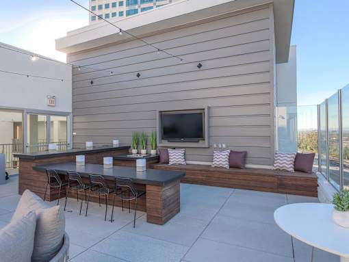 A modern outdoor patio with a bar and seating area.