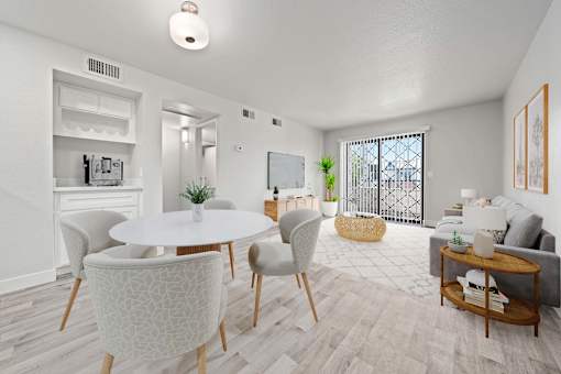 A white dining table with chairs and a sofa in a room.
