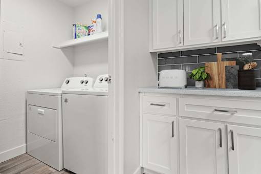 A white laundry room with a washer and dryer.