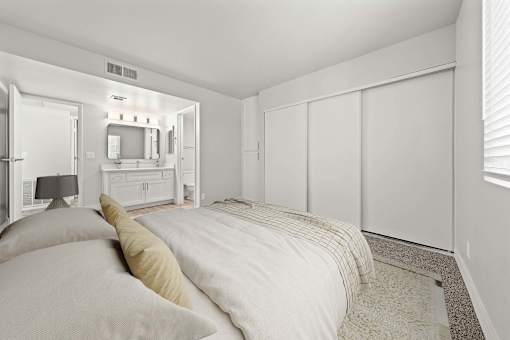 A bedroom with a bed, a dresser, and a mirror.