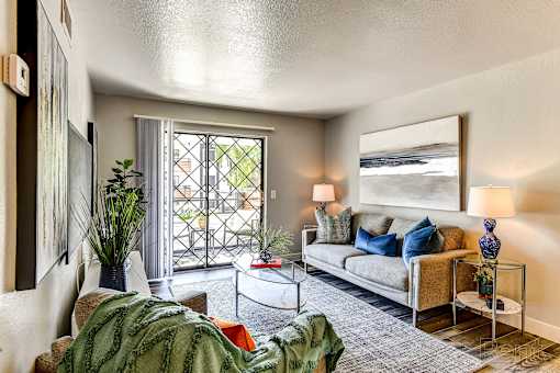 A living room with a couch, a coffee table, and a painting on the wall.