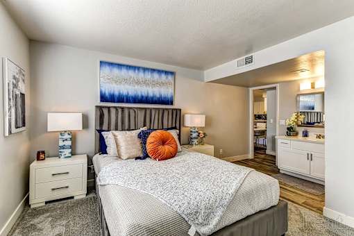 A bedroom with a large bed and a painting on the wall.