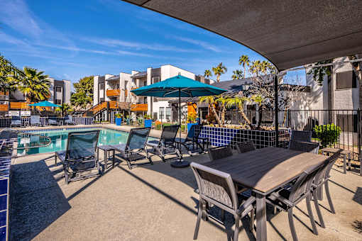 A poolside area with chairs and a table.