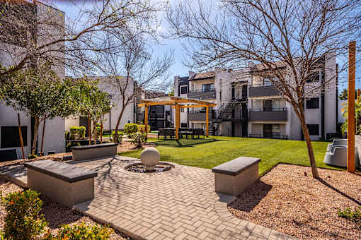 A courtyard with a fountain and benches in front of a building.