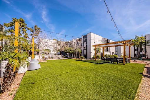 A large grassy area with a wooden structure and a bench.
