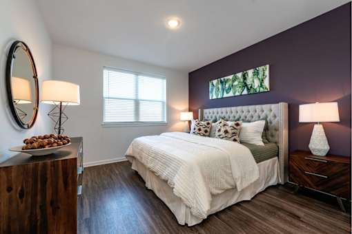 Spacious bedroom with bright windows and plank flooring